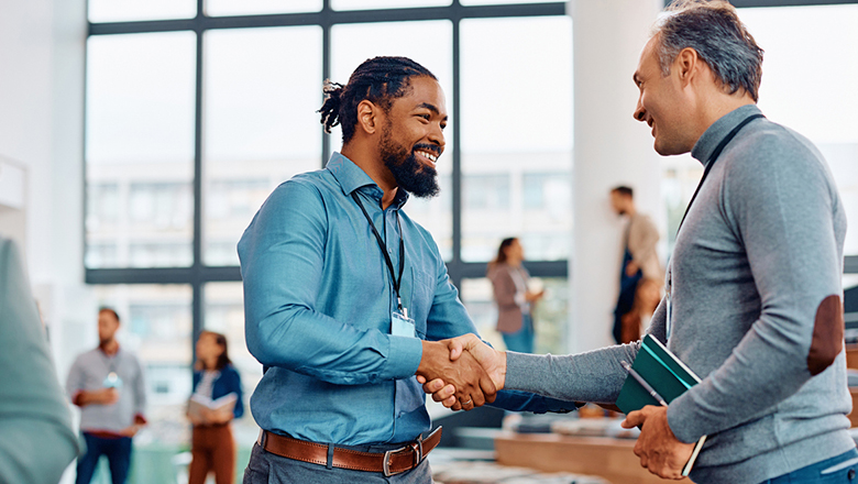 Two men shaking hands at association conference