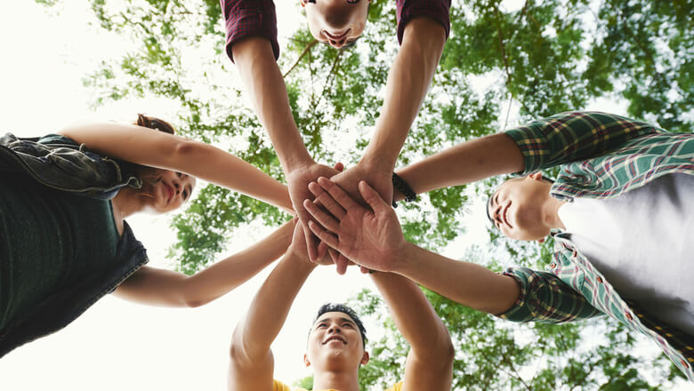 A group of people with their hands in a circle