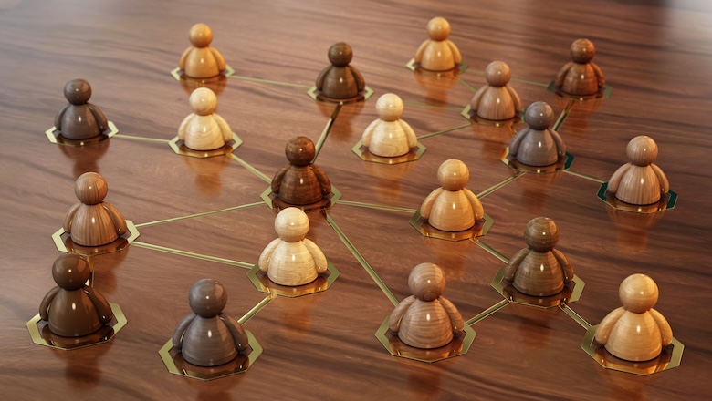 Diverse wooden figurines are connected in a network formation